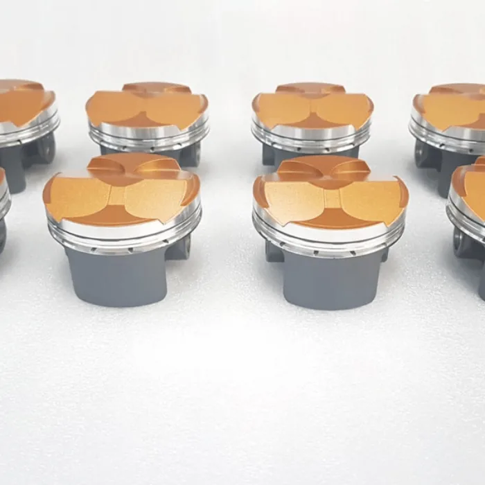 Pistons with gold thermal barrier coated crowns
